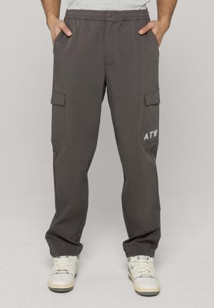 Donkere grijze cargobroek met een elastische tailleband, zijzakken en een zak met een label waarop "ATW" in het wit staat. Glad, lichtgewicht materiaal.