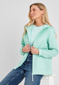Lightweight, mint green windbreaker with elastic cuffs and adjustable hood; features a central zipper and logo detail on the chest.
