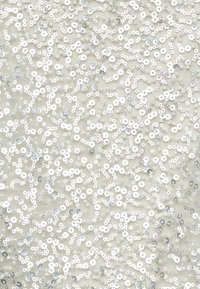 Tissu blanc couvert de paillettes argentées et de perles éparpillées, présentant une surface texturée qui réfléchit la lumière. Pas de motifs distincts.