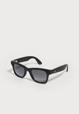 Black plastic sunglasses with gradient gray lenses, square shape, and Ray-Ban logo on the side. Features accent holes on the frame.