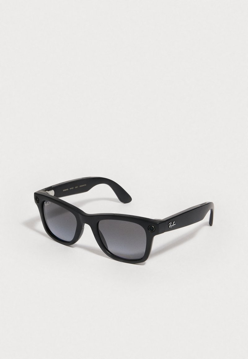 Black plastic sunglasses with gradient gray lenses, square shape, and Ray-Ban logo on the side. Features accent holes on the frame.