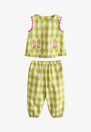 Detský overal s kockovaným vzorom v zelenej a bielej farbe, bez rukávov s ružovými vreckami v tvare kvetín a elastickými nohavicami so zladeným pásom a členkami.