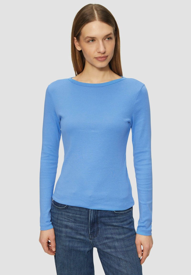 Helles blaues Langarmshirt mit Rundhalsausschnitt, aus weichem, dehnbarem Stoff, kombiniert mit dunkelblauen Jeans. Figurbetonter Schnitt.