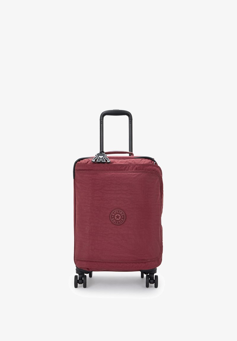 Red nylon spinner suitcase with a textured finish, black handle and wheels, featuring a circular logo on the front and zipper closure.