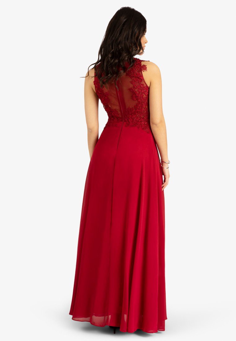 Langes rotes Abendkleid mit tailliertem Oberteil, transparenter Rückenpartie und floraler Stickerei. Der Rock fließt bis zum Boden und hat eine glatte Textur.