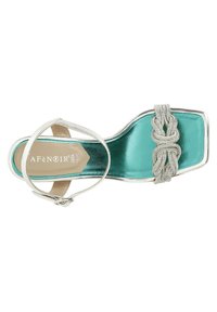 Sandal tinggi dengan tali berpita berwarna perak metalik, dengan insole berwarna turquoise, dan detail anyaman yang dihiasi di area jari kaki.