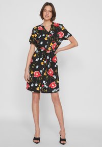 Abito nero floreale con maniche corte, vita stretta e fiori colorati in rosso, arancione e blu; tessuto leggero con una silhouette rilassata.