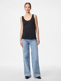 Juodos spalvos rankovių neturintis tankinis viršus su apvalia iškirpte, pagamintas iš lygaus audinio, derinamas su šviesiai mėlynais plačiomis kojomis džinsais ir juoda avalyne.