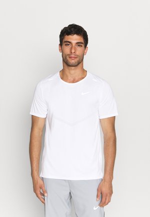 Camiseta deportiva blanca Nike de manga corta, cuello redondo, tela texturizada y sutil diseño de Chevron en la parte delantera.