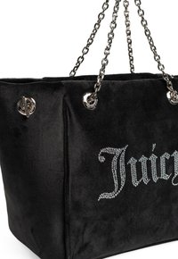 Zwarte suède tote bag met een kettingriem, metallic hardware en strassversiering die "Juicy" aan één zijde spelend.