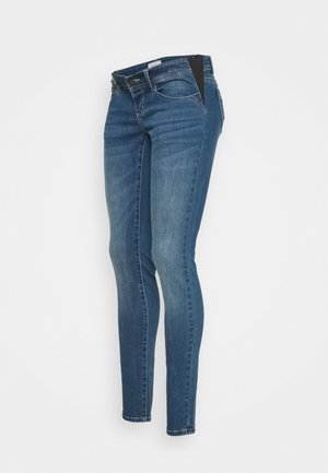 Tight jeans i denim med medelblå tvätt, lätt blekning, femfickdesign och en svart accent på midjebandet.
