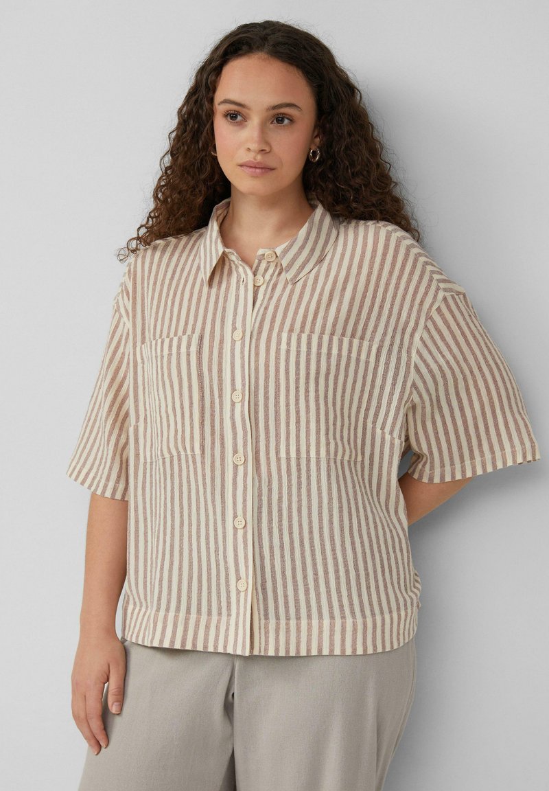 Chemise à manches courtes avec un col, présentant des rayures verticales beiges et marron. Deux poches poitrine et une coupe décontractée.