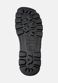Black rubber shoe sole with textured tread pattern, imprinted logo "CAMPER," and size "42" near the heel. Durable and functional design.