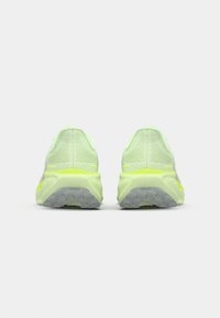 Zapatillas deportivas de color amarillo neón con una parte superior de malla transpirable, suela acolchada y suela de goma con un patrón de agarre texturizado.