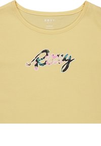 Camiseta amarilla de algodón orgánico con un colorido diseño floral y el logo en cursiva de "Roxy" en negro. Cuello redondeado y mangas cortas.
