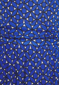 Tissu bleu avec un motif répétitif d'ovales aux contours noirs et de formes de feuilles sur fond blanc, montrant des plis et des lignes de couture.