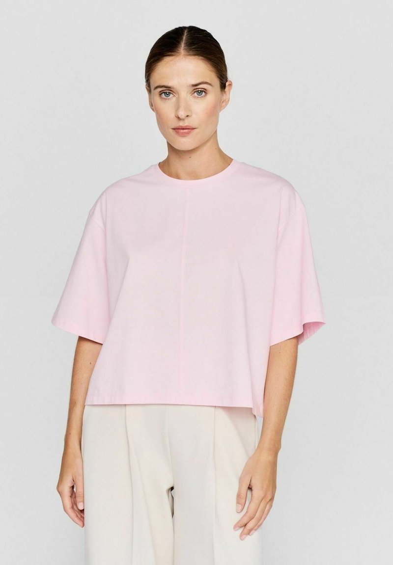 Roze cropped t-shirt met korte mouwen, ronde halslijn en een ontspannen pasvorm. Glad katoen materiaal met een subtiele glans en minimale stikdetails.