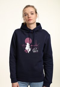 Marinblå hoodie med snoddar som har en grafik av Paris, inklusive Eiffeltornet och en silhuett mot en rosa solnedgång.