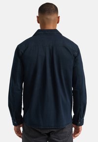 Dunkelblauses Langarmhemd aus Denim, mit Kragen, knöpfbaren Manschetten und geradem Saum sowie einer lockeren Passform.