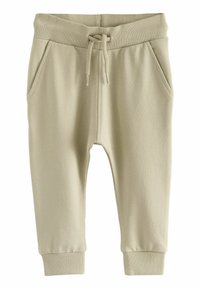 Pantalons jogger en coton beige avec une taille côtelée, un cordon de serrage et des poches latérales. Présente des jambes fuselées avec des poignets côtelés. Texture lisse.