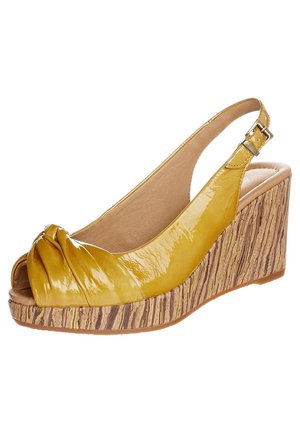 Gul lakeret kile sandal med åbent tådesign, knude detalje på oversiden og en tekstureret platform i naturligt trælook.