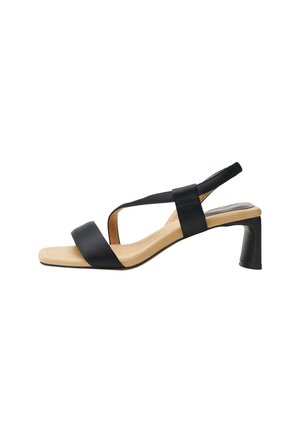 Black open-toe sandal with two crossed straps, a square toe design, and a sturdy block heel. Smooth leather upper and beige sole.