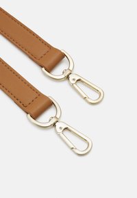 Hnědý syntetický pásek s pozlacenými kovovými detaily, otočnými háčky a prošíváním podél okrajů pro zvýšení odolnosti.