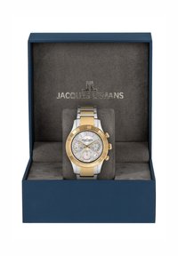 Orologio tondo con bracciale in acciaio inossidabile argento e oro, dotato di un quadrante riflettente chiaro, tre sotto-quadranti e una lunetta dorata in una scatola.
