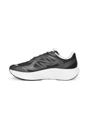 Chaussure de sport noire avec une tige en mesh respirant, des accents synthétiques, un col rembourré, et une semelle blanche amortissante. Comprend un logo sur le côté.
