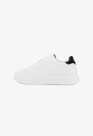 Witte leren sneaker met een gladde oppervlakte, ronde neus en een zwarte lakleren accent op de hiel. Voorzien van platte veters en een dikke zool.