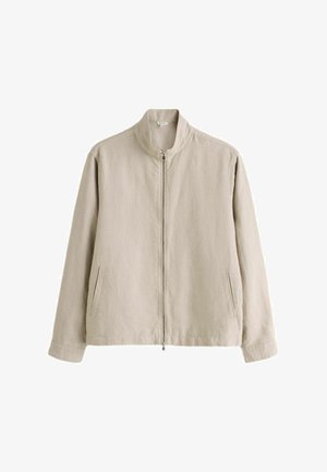 Beežika kerge kangaast valmistatud pikkade varrukatega vabaajajakk, millel on kõrge krae, esil lukk ja kaks küljetaskut lõhikutega.