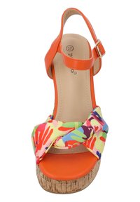 Flerfärgad plattformssandal med ett orange syntetiskt överdel, en korksula och ett knutet tygband med ett livligt handavtrycksmönster.