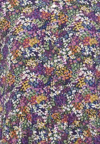 Gros plan d'un tissu avec un motif floral dense en violet, vert, orange, blanc et jaune, présentant de petites fleurs et des boutons métalliques au centre.