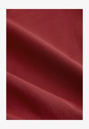 Sügavpunane kangas, millel on sile tekstuur ja õrn sooneline muster, esitleb rikkalikku värvi ja pehmet, paindlikku välimust.