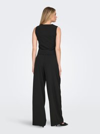 Black sleeveless top with a straight cut, paired with wide-legged black pants. Smooth texture and minimalistic design. No notable accents.