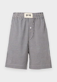 Σορτς με σχέδιο γκινγκάμ σε ναυτικό μπλε και μπεζ, με ελαστική μέση, κουμπιά μπροστά και άνετη εφαρμογή. Η ετικέτα γράφει "HOUSE OF SUNNY".