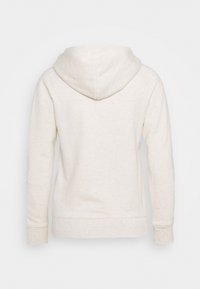 Sudadera beige claro de textura suave, con un bolsillo tipo canguro, puños ribeteados y capucha ajustable con cordón.