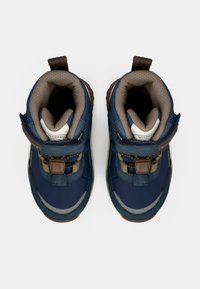 Une paire de bottes d'hiver pour enfants, bleu marine et marron, avec des cols rembourrés et des bandes auto-agrippantes, vues du dessus sur fond blanc.