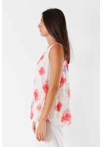 Top floreale senza maniche in un tessuto leggero e trasparente con base bianca e grandi motivi di rose rosse, completato da morbidi accenti pastello.