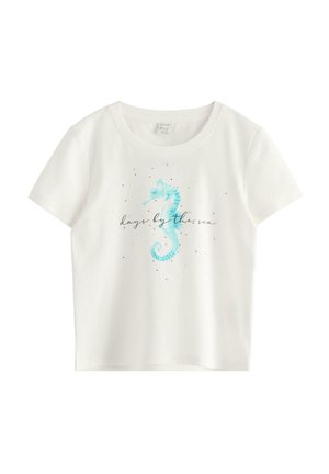 Hvid T-shirt med korte ærmer med et lyseblåt søheste-motiv og teksten "dage ved havet" i kursiv på forsiden.