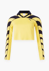 Gul kortärmad långärmad tröja med svarta accenter, en polo krage och en texturerad yta med ett dynamiskt randmönster. Puma-logotyp ingår.