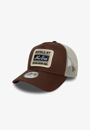 Gorra de béisbol marrón con parte trasera de malla, con un parche rectangular color crema que tiene el texto "Buffalo, NY" y "New Era" en azul oscuro. Tamaño ajustable.