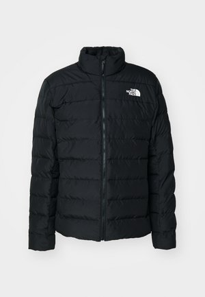 Schwarze Steppjacke mit gesteppten Abschnitten, hohem Kragen, Frontreißverschluss und kleinem weißen Logo auf der linken Brust. Leichtgewichtiges und isoliertes Design.