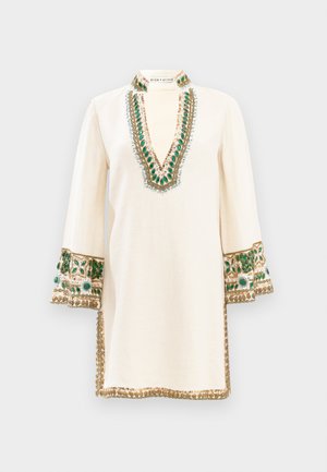 Geborduurde tuniek in crèmekleurig linnen met een diepe V-hals, voorzien van groene en gouden accenten, uitlopende mouwen en intrigerende details langs de randen.