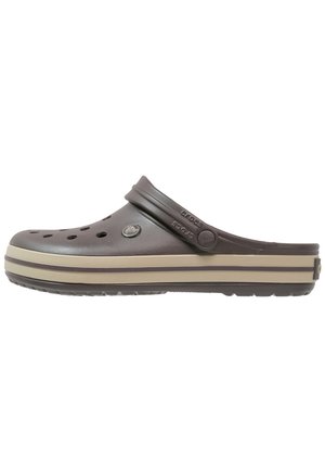 Brun slip-on træsko med ventilationshuller, justerbar hælrem og en beige og brun stribet sål.
