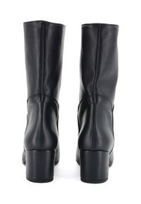 Stivali ankle in pelle nera con una consistenza liscia, alti tacchi a blocco e dettagli di cucitura minimi, che mostrano un design elegante e moderno.