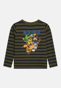 Long-sleeve shirt in olive green with navy stripes. Features a colorful "Ninjago" graphic on the back of four character figures.
