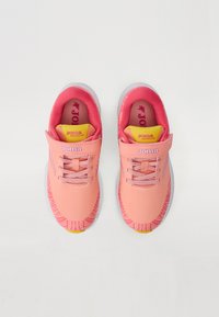 Roze hardloopschoenen met een geprofileerd ontwerp, voorzien van een mesh bovenkant, veters en een klittenbandsluiting. Gele en roze accenten op de binnenzool.