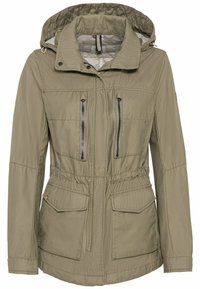 Veste à capuche vert olive avec fermeture éclair à l'avant, deux poches poitrines zippées verticales, cordon de serrage à la taille, et deux poches à rabat au niveau des hanches.