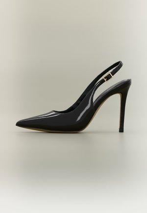 Chaussure slingback à talon haut en cuir verni noir avec bout pointu et boucle dorée sur fond neutre.